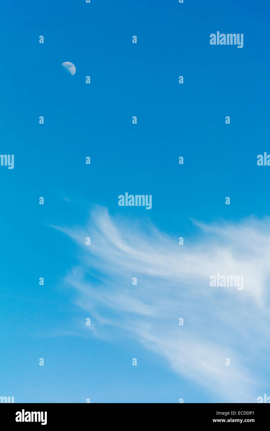 Half Moon e Wispy nuvole nel cielo blu Foto Stock