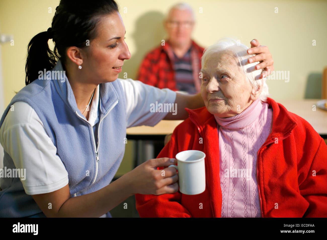 Donna, 88 anni, in una casa di cura, a colazione, supportato da un infermiere geriatrico, Foto Stock