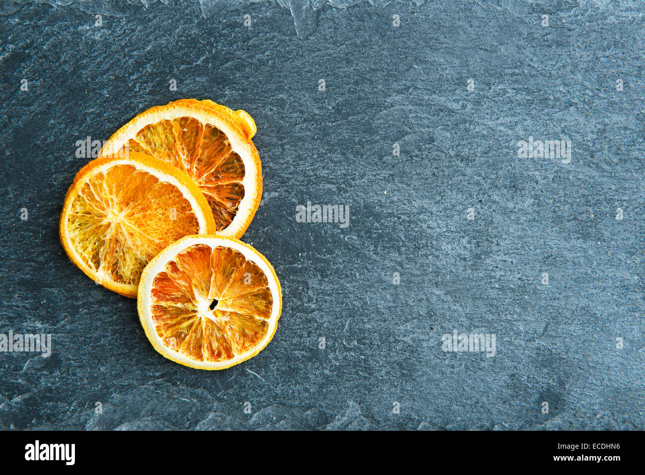 Primo piano su essiccato fettine di arancia sul substrato di pietra Foto Stock