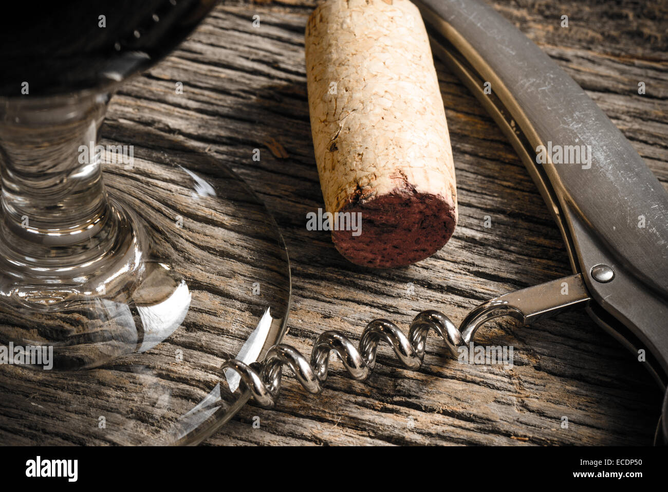 Bicchiere da vino con sughero e cavatappi su tavola in legno rustico Foto Stock