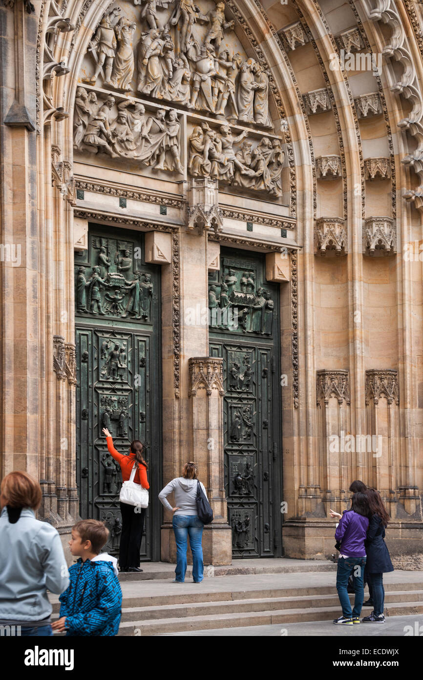 I turisti ammirando riccamente intagliato porta a Chram svateho Vita (St. Cattedrale di San Vito) cattedrale gotica in Prazsky Hrad Foto Stock