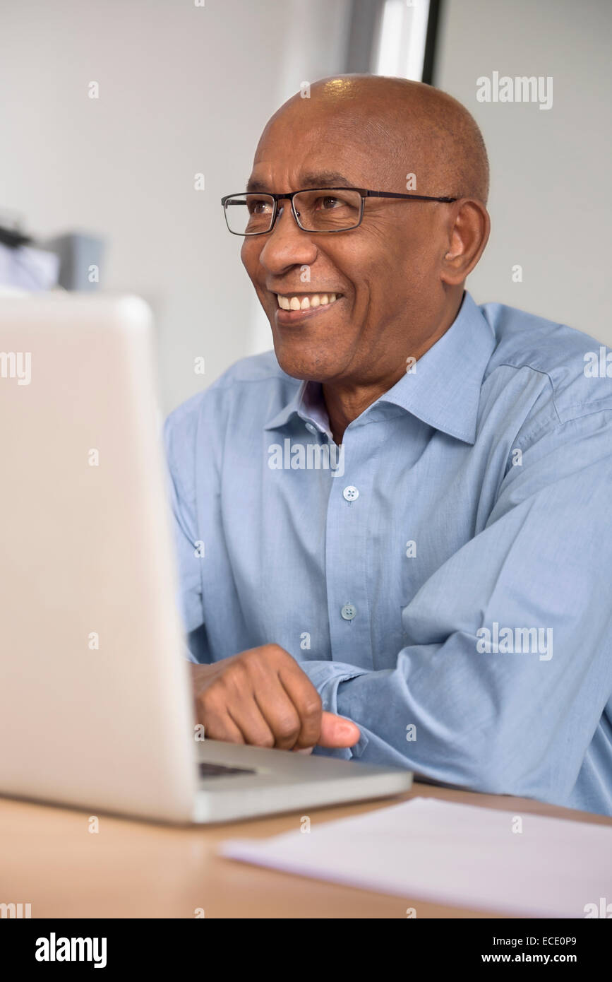 Imprenditore sorridente desk africano del computer Foto Stock