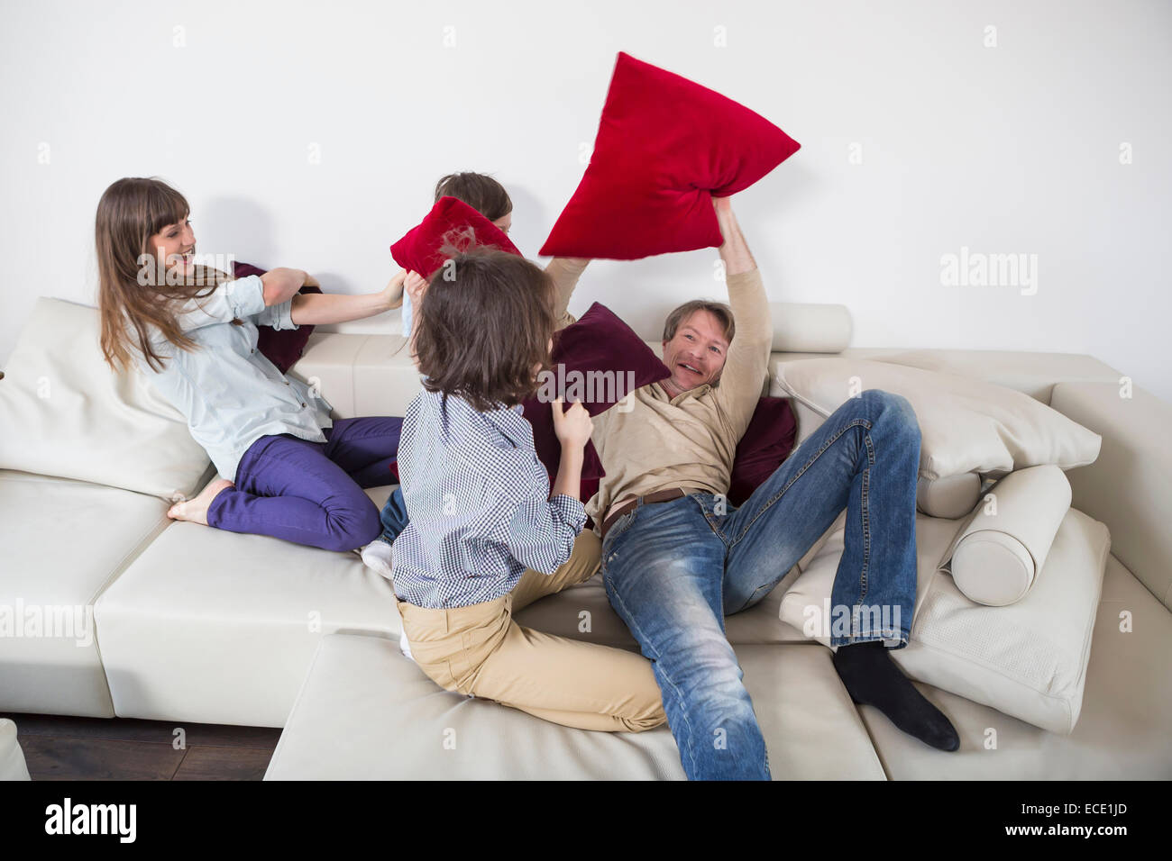 Famiglia facendo pillow fight sul lettino Foto Stock