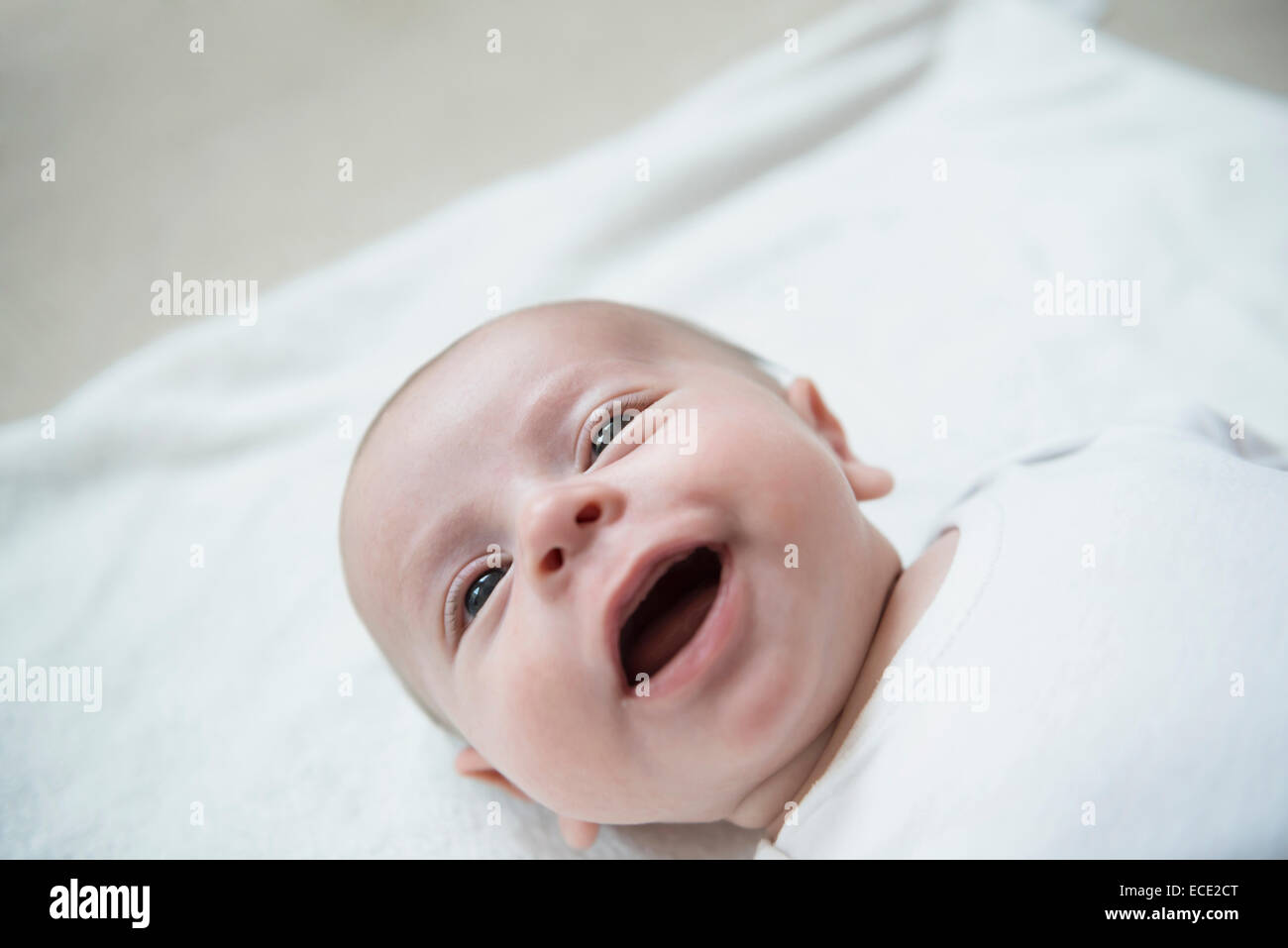 Bambino giacente sul letto, sorridente Foto Stock