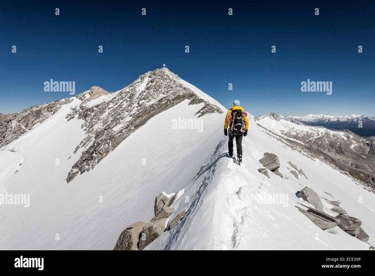 Alpinista sul vertice ridge durante la salita del Mt Hoher Weißzint, vertice di croce sul retro, la catena principale delle Alpi Foto Stock
