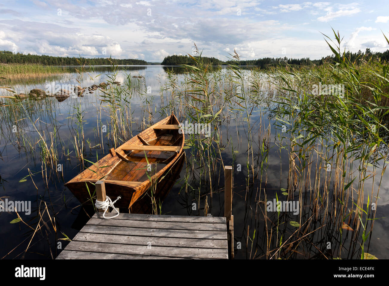 Barca dock con canotto, canne, il lago in Smaland, Svezia Foto Stock
