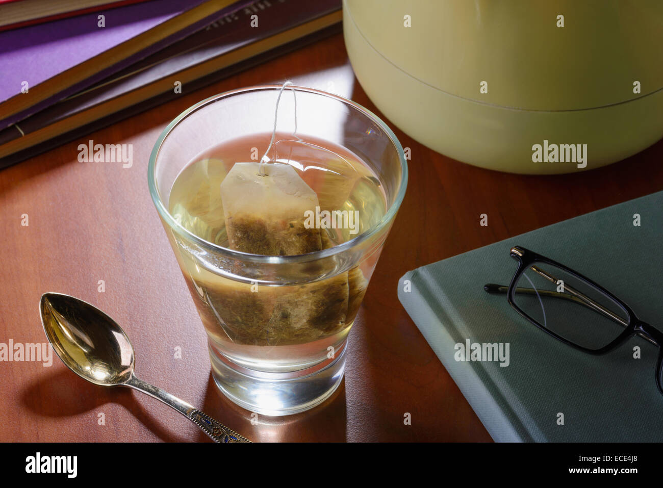 Un momento di relax sorseggiando un bicchiere di tè caldo o altri tisane, durante la lettura di libri Foto Stock