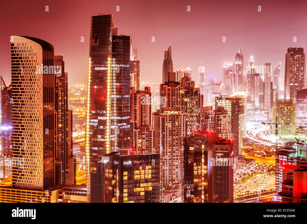 Bellissimo sfondo di Dubai alla notte, splendido paesaggio su rosa sky, molte luci incandescenti di alti grattacieli, moderno e di lusso Foto Stock