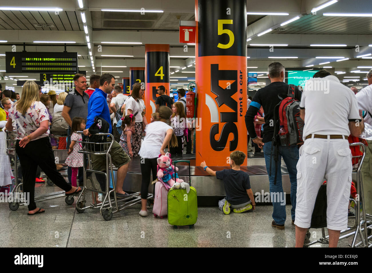 Passeggeri in attesa di bagagli in un carosello aeroportuale Foto Stock