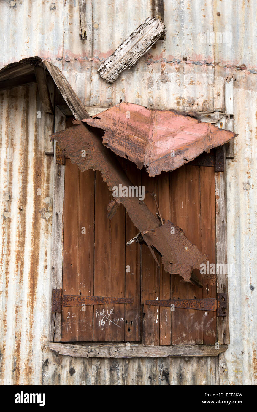 Maurizio, Mahebourg, ruted finestra della modesta casa locale costruito dal ferro corrugato fogli Foto Stock