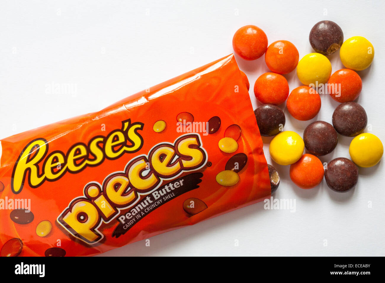 Pacchetto di Reese's pezzi burro di arachidi caramella in un guscio croccante con contenuto versato su sfondo bianco - caramelle caramelle Foto Stock