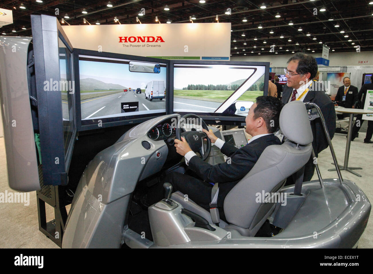 Detroit, Michigan - Partecipanti ai sistemi di trasporto intelligenti congresso mondiale in una Honda simulatore di guida. Foto Stock