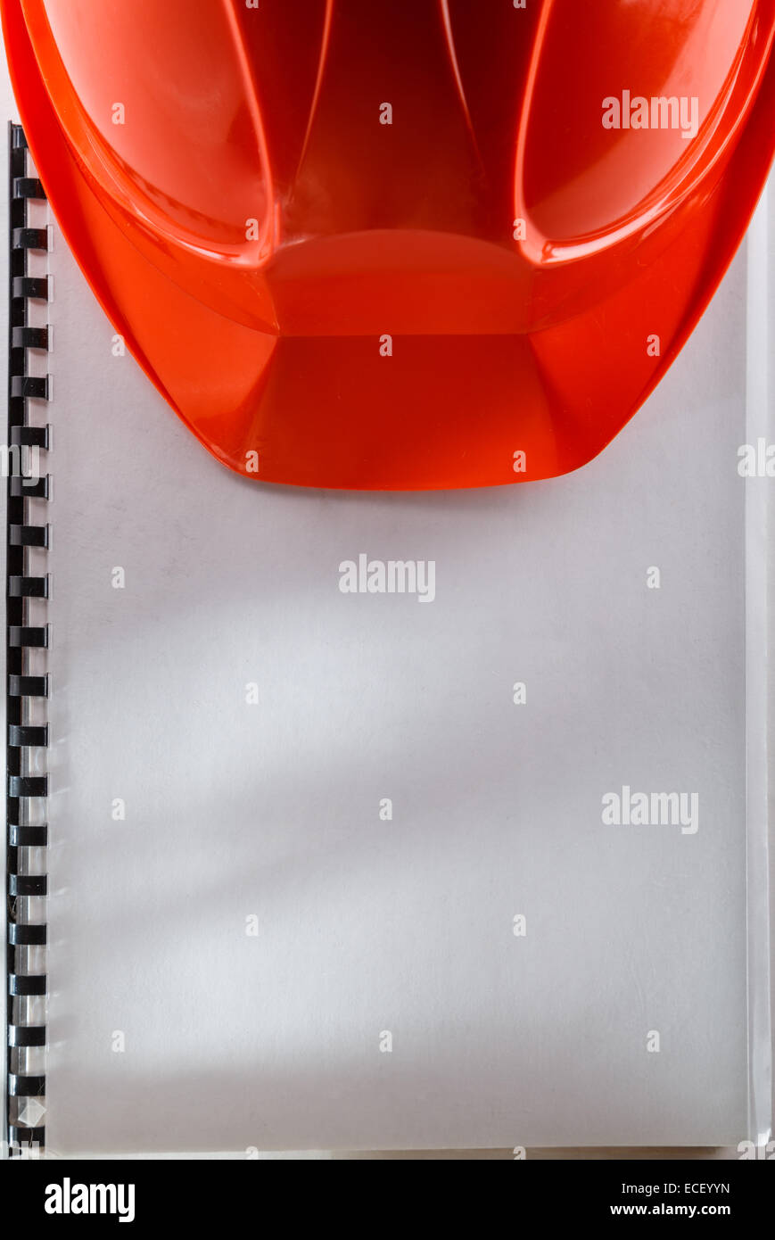 Casco rosso su bianco notebook Foto Stock