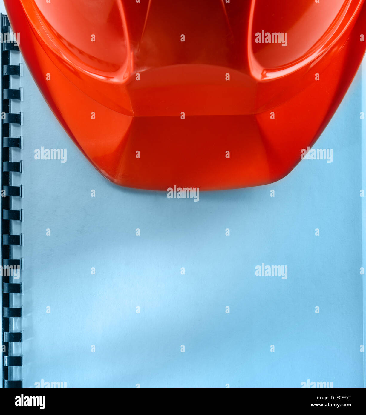 Casco rosso su bianco notebook Foto Stock