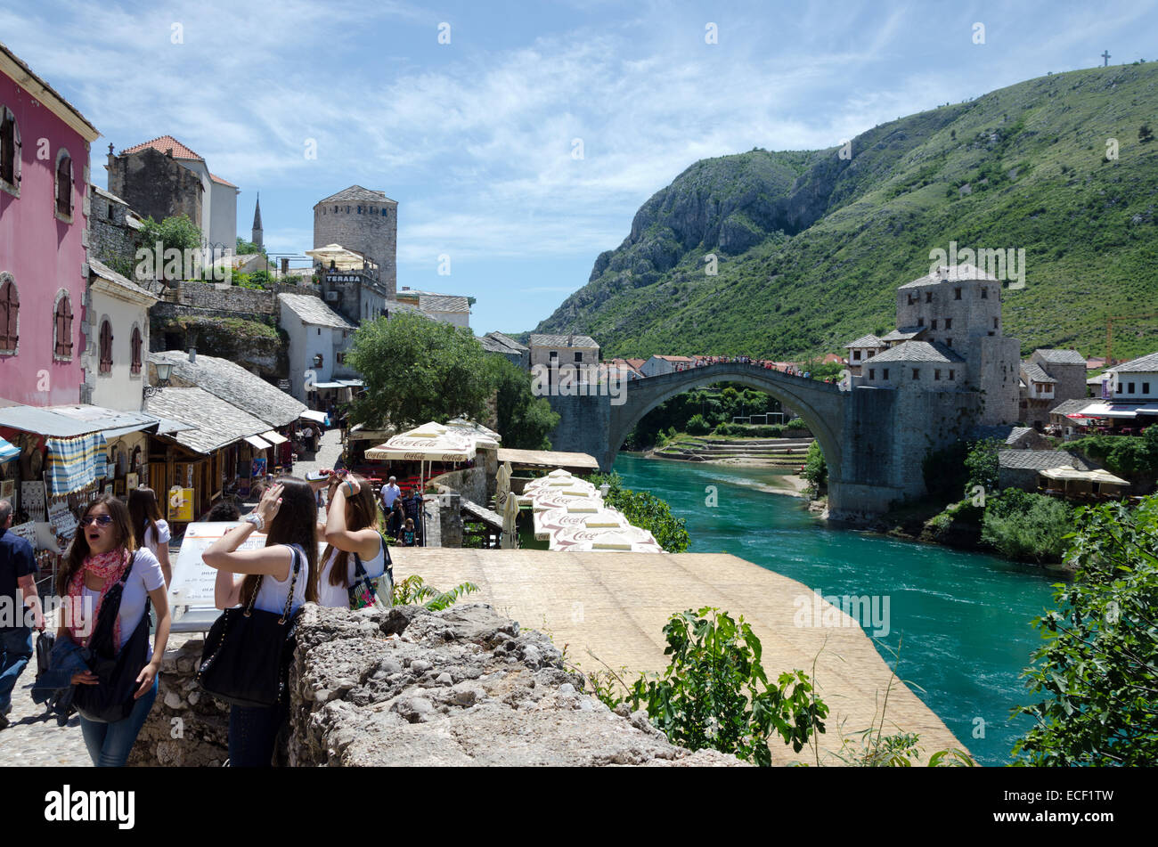 MOSTAR, BOSNIA ERZEGOVINA - 18 Maggio 2013: tre giovani turisti donna a Mostar. In fondo è il ponte sopra il ne Foto Stock