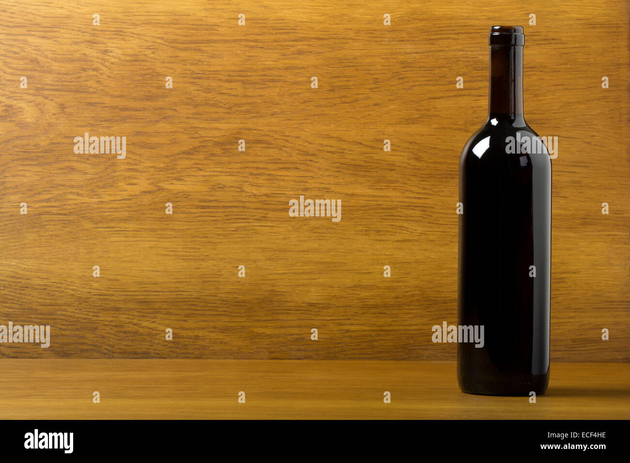 Rosso bottiglia di vino su uno sfondo di legno Foto Stock