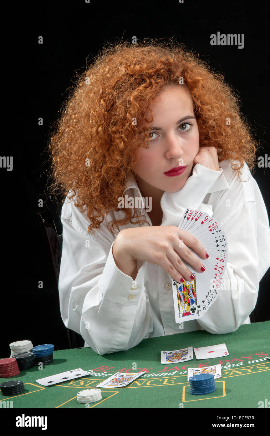 Giovane donna croupier al tavolo verde, mentre si occupano delle carte Foto Stock