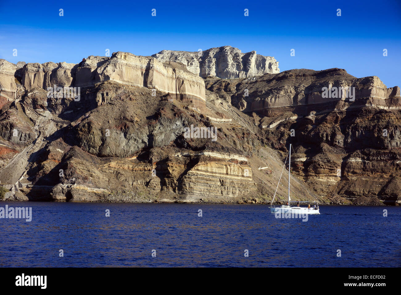 Grandi scogliere e il bordo della caldera, il cratere vulcanico, Santorini, con yacht Foto Stock