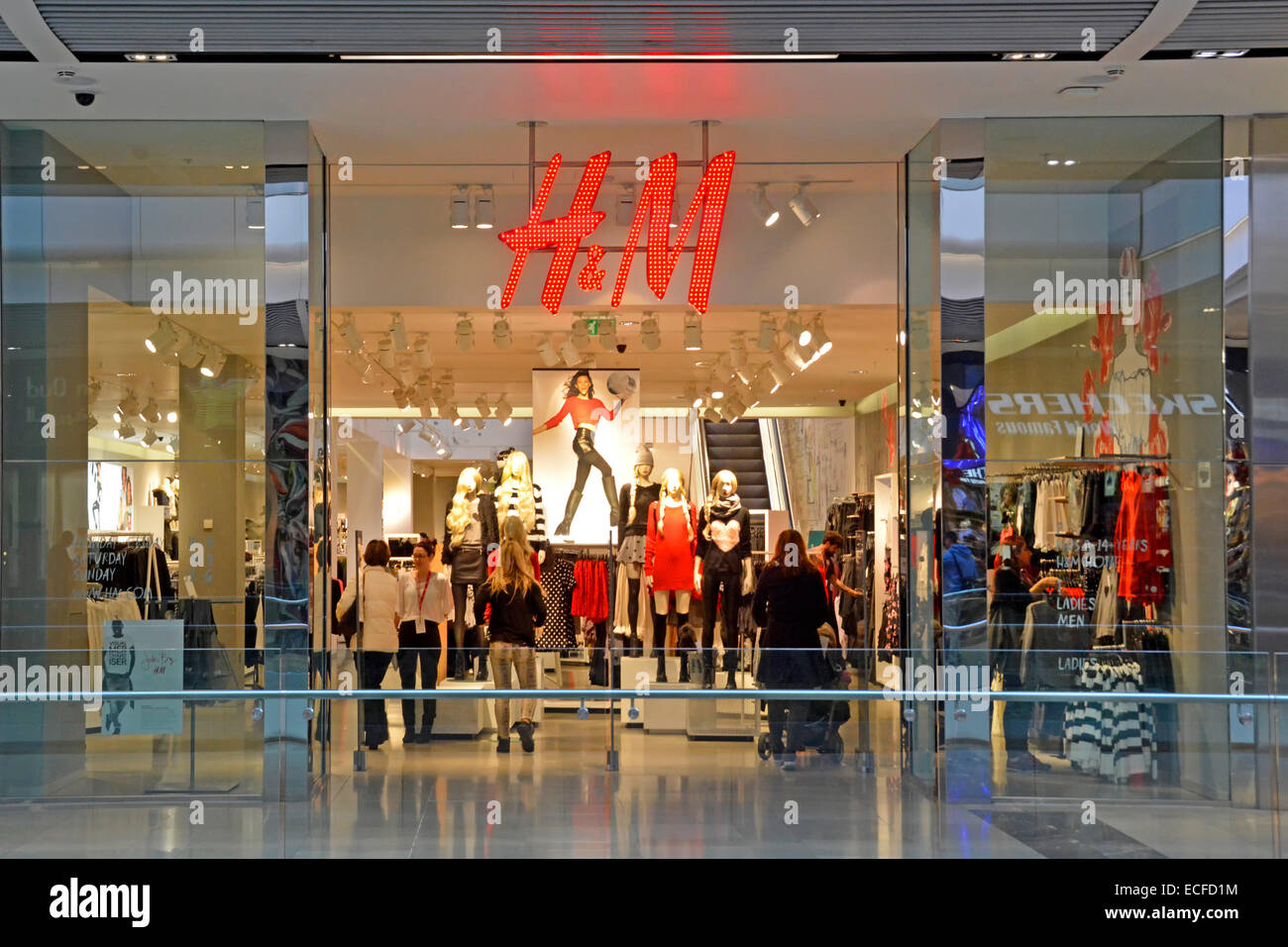 H&M negozio con vedute interne attraverso il negozio di fronte finestra visualizza e ingresso Foto Stock