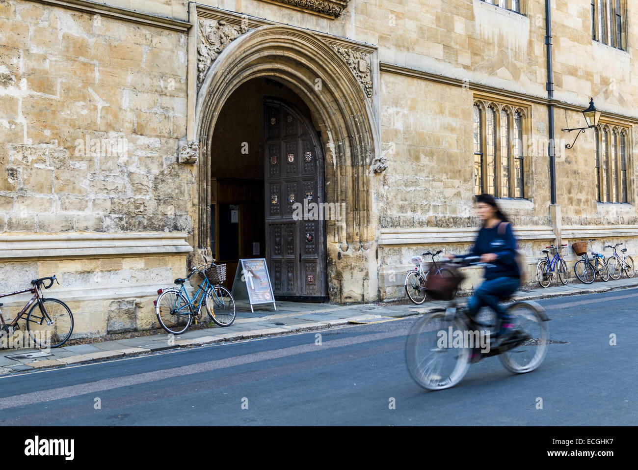 Un ciclista passa la porta per la Libreria di Bodleian su Catte Street, la biblioteca dell Università di Oxford Foto Stock