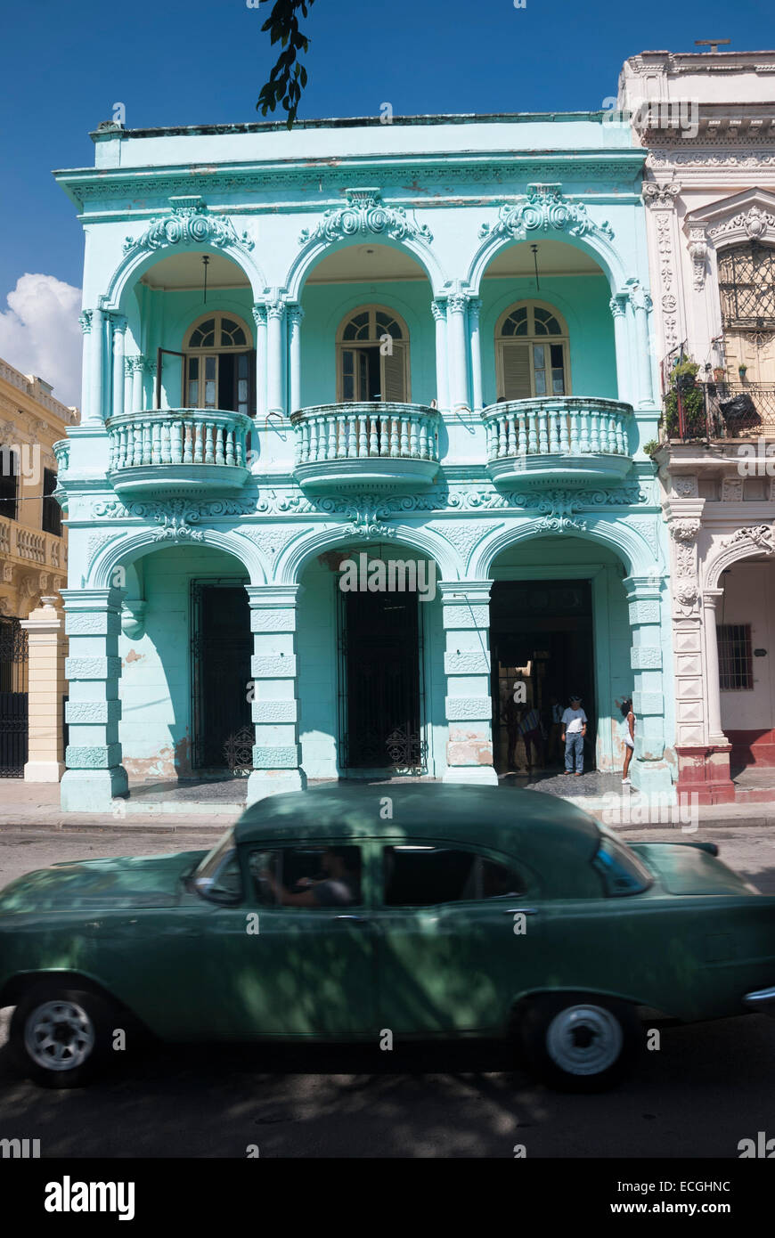 Un'auto d'epoca passa un esempio colorato di architettura coloniale spagnola restaurata sul Prado (Paseo de Marti) a l'Avana Cuba Foto Stock