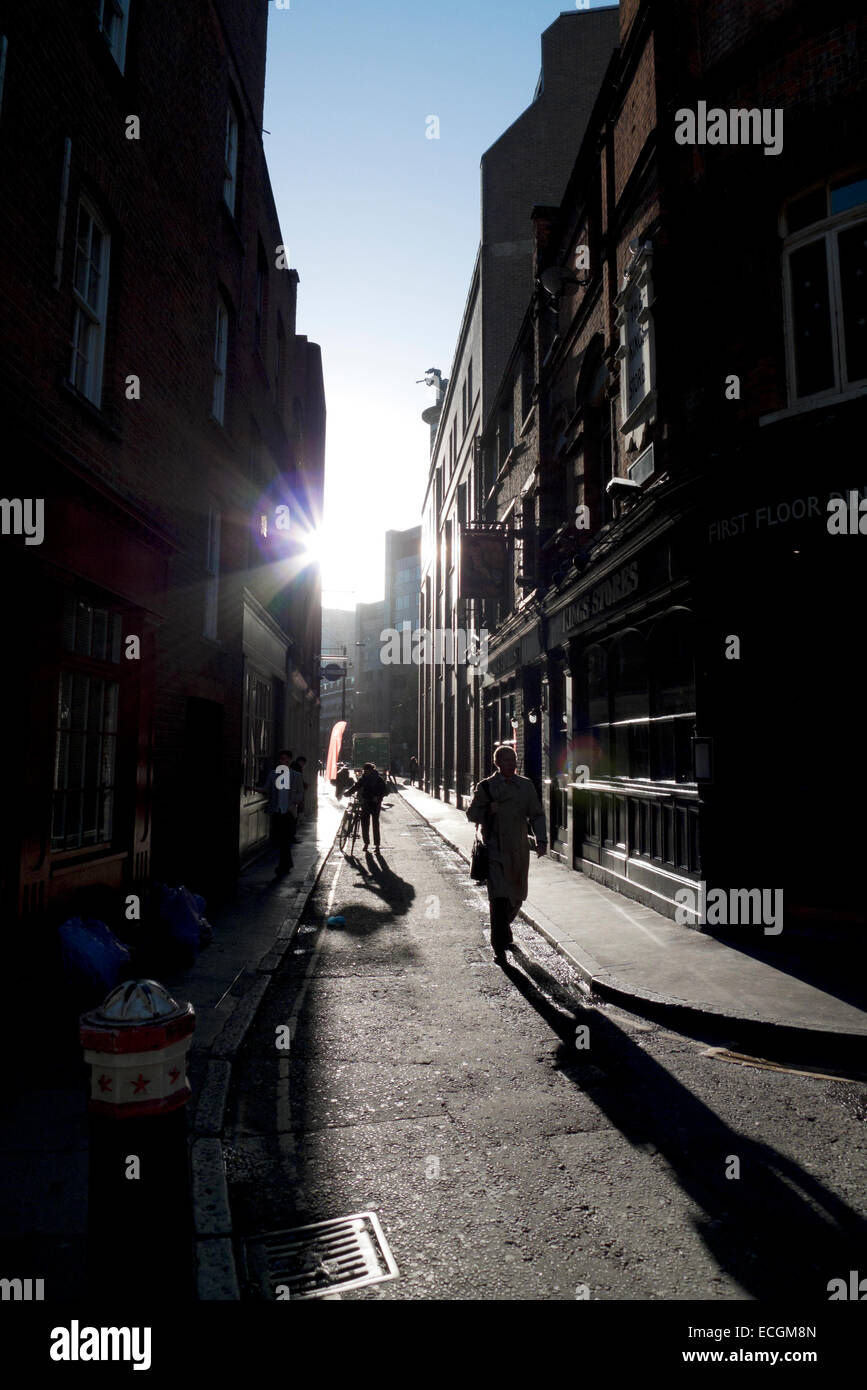 Pedoni, sole e ombre in corrispondenza della zona di spigolo di Sandy Row & Widegate Street Spitalfields London, Regno Unito KATHY DEWITT Foto Stock