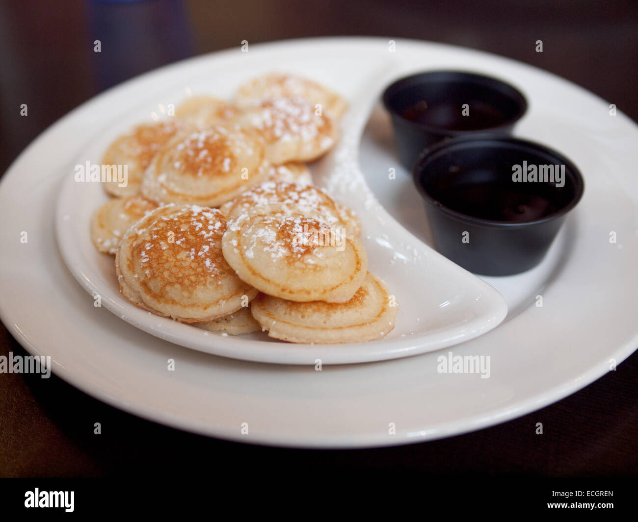 Morso dimensioni North American dollar pancakes, spolverato con zucchero a velo. Foto Stock