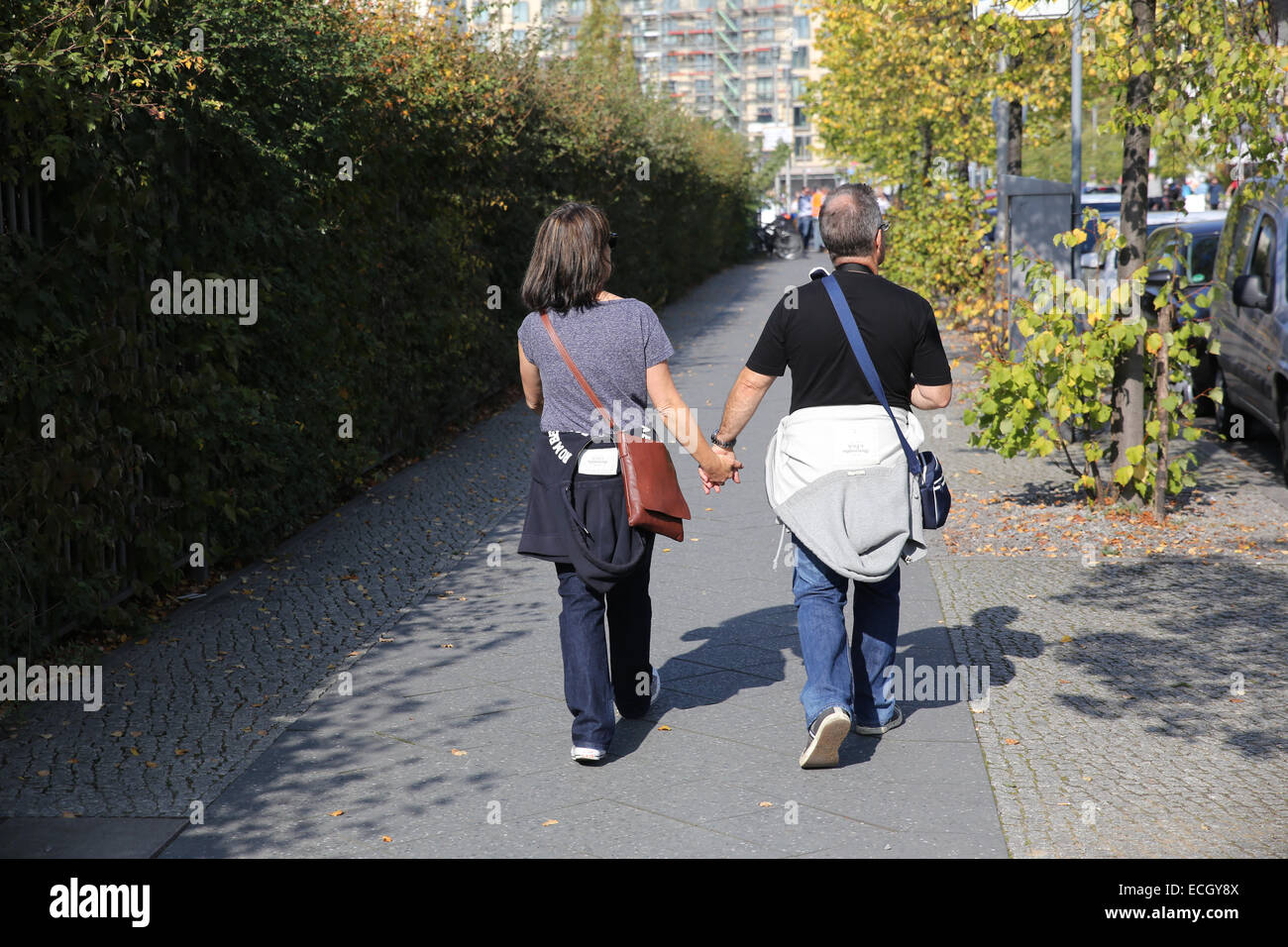 La mezza età giovane azienda appendere walking street Berlin Germania Europa Foto Stock