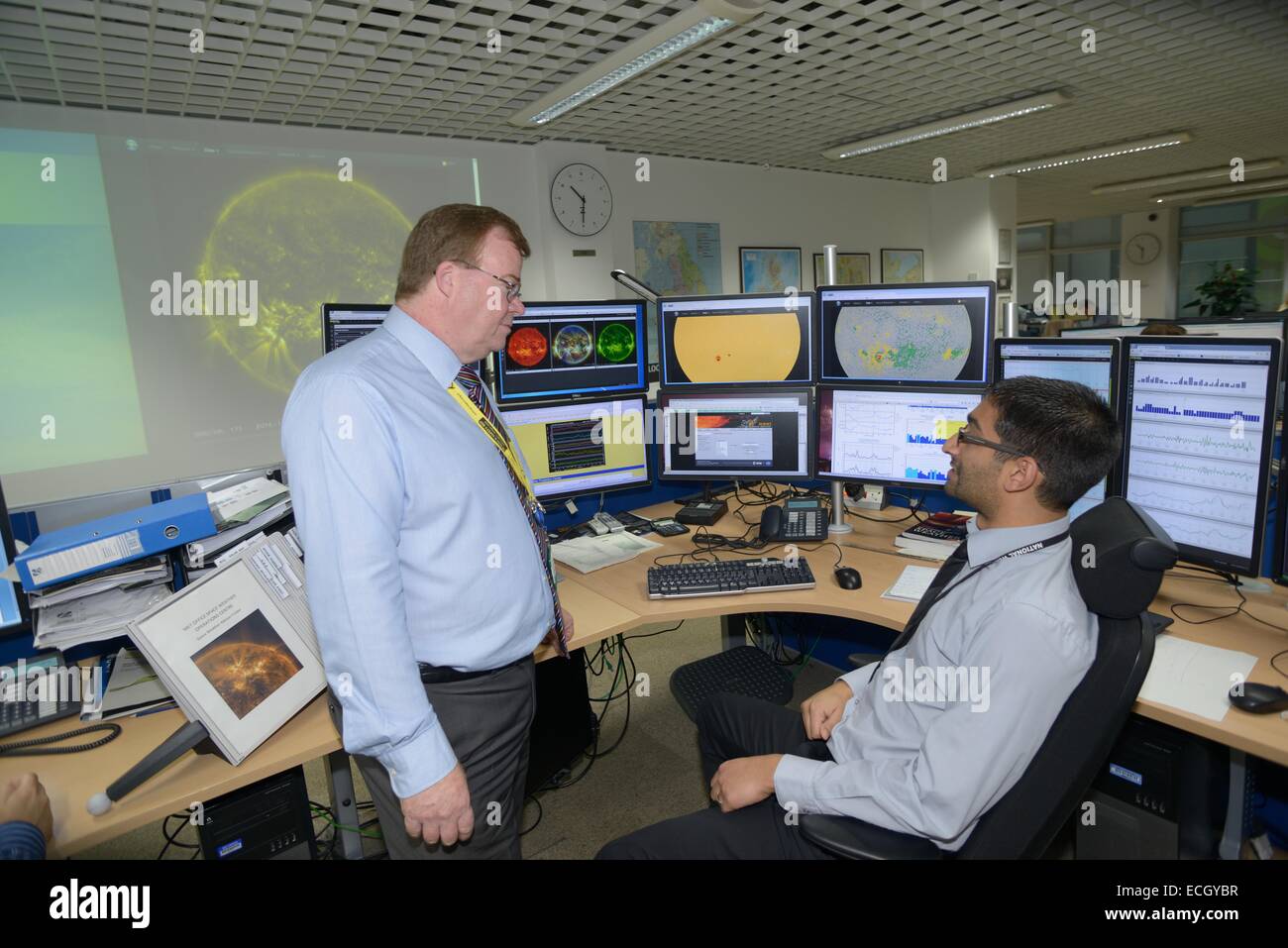 Met Office britannico - Mark Seltzer, Senior Operations Meterologist nello spazio centro meteorologico, con Sun spot su schermi dietro, talk Foto Stock