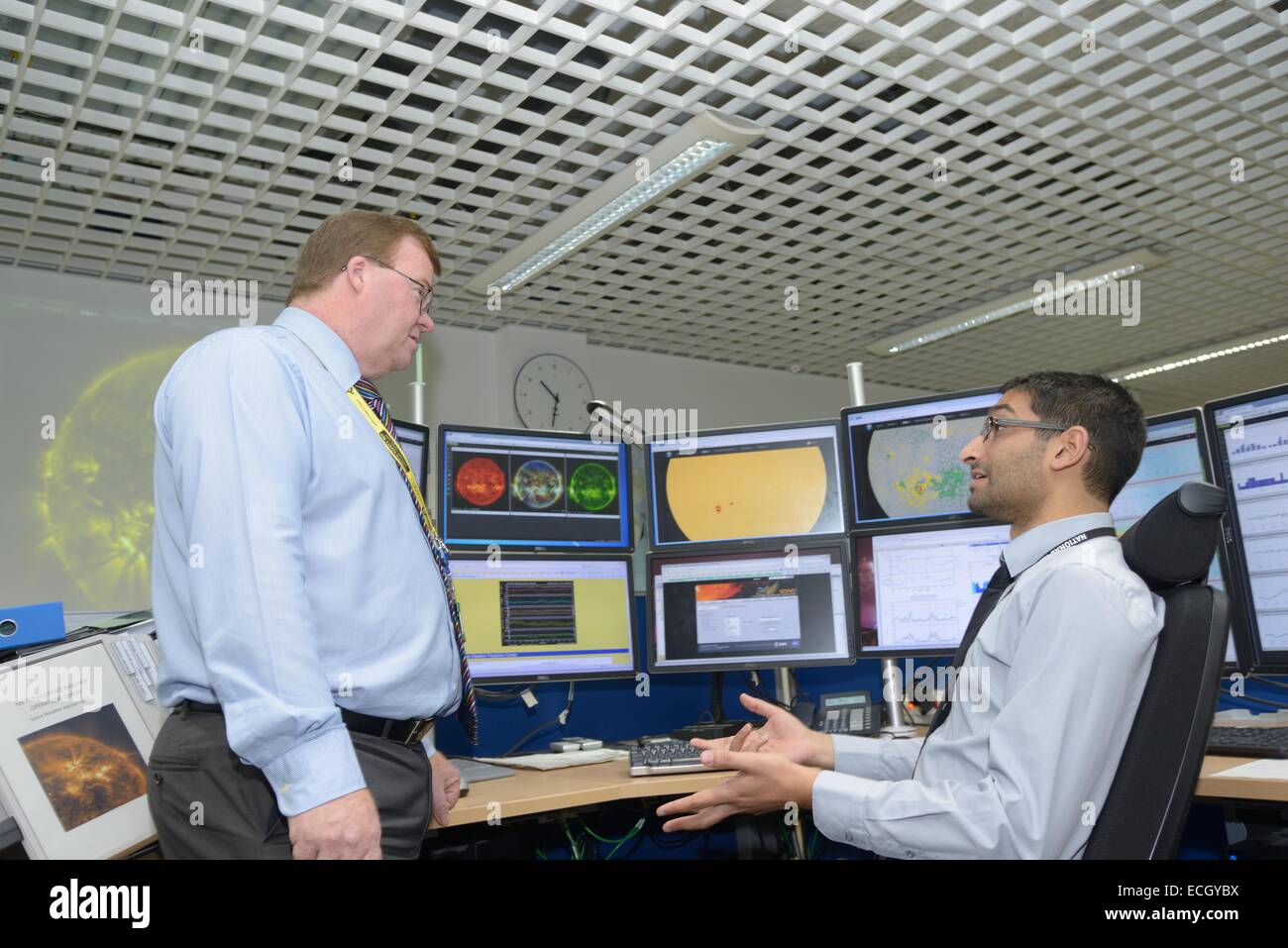 Met Office britannico - Mark Seltzer, Senior Operations Meterologist nello spazio centro meteorologico, con Sun spot su schermi dietro, talk Foto Stock