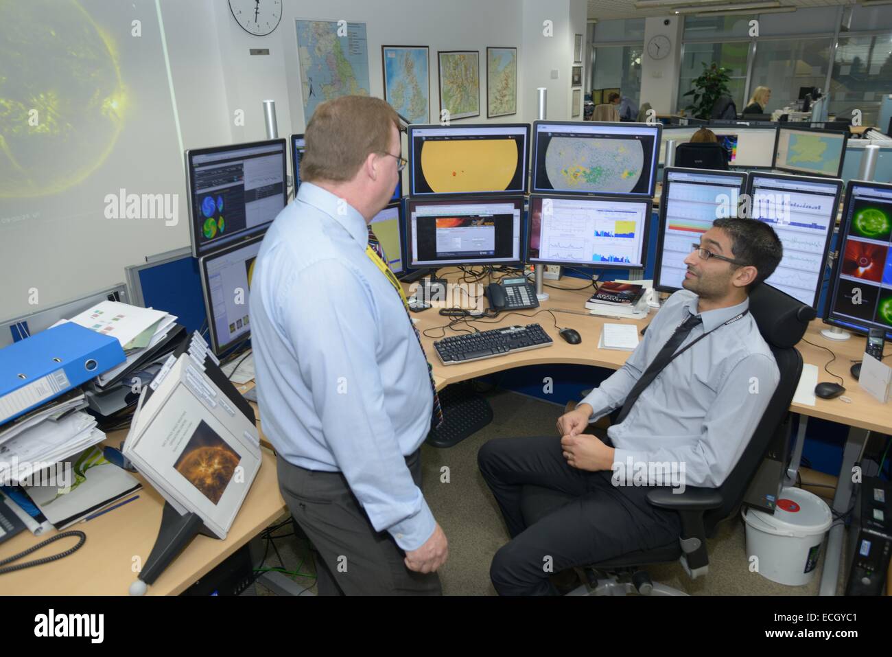 Met Office britannico - Mark Seltzer, Senior Operations meteorologo nello spazio centro meteorologico, con Sun spot su schermi dietro Foto Stock