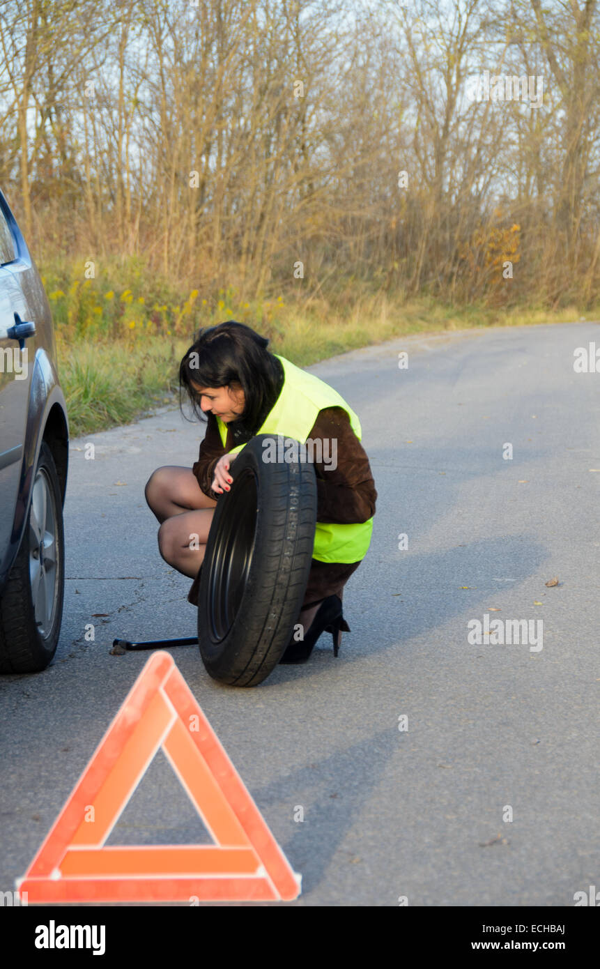 Una foto di una donna con una ruota rotto in auto Foto Stock