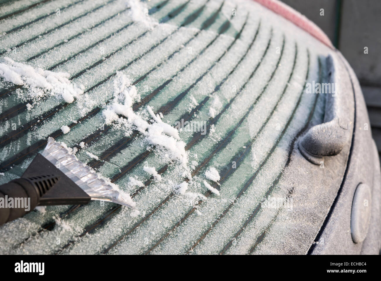 Lo sbrinamento posteriore di un parabrezza di automobile su un gelido inverno mattina in Inghilterra. Foto Stock