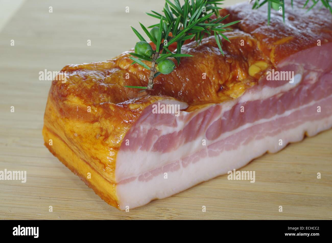 La pancetta affumicata con juniper sul tagliere Foto Stock