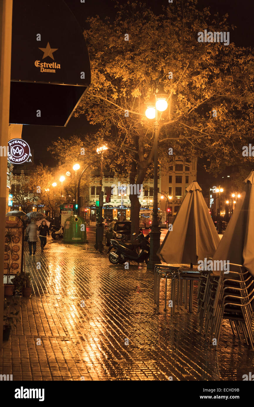 Umide e piovose strade della città di Valencia durante la notte con le luci di strada e riflessioni Foto Stock