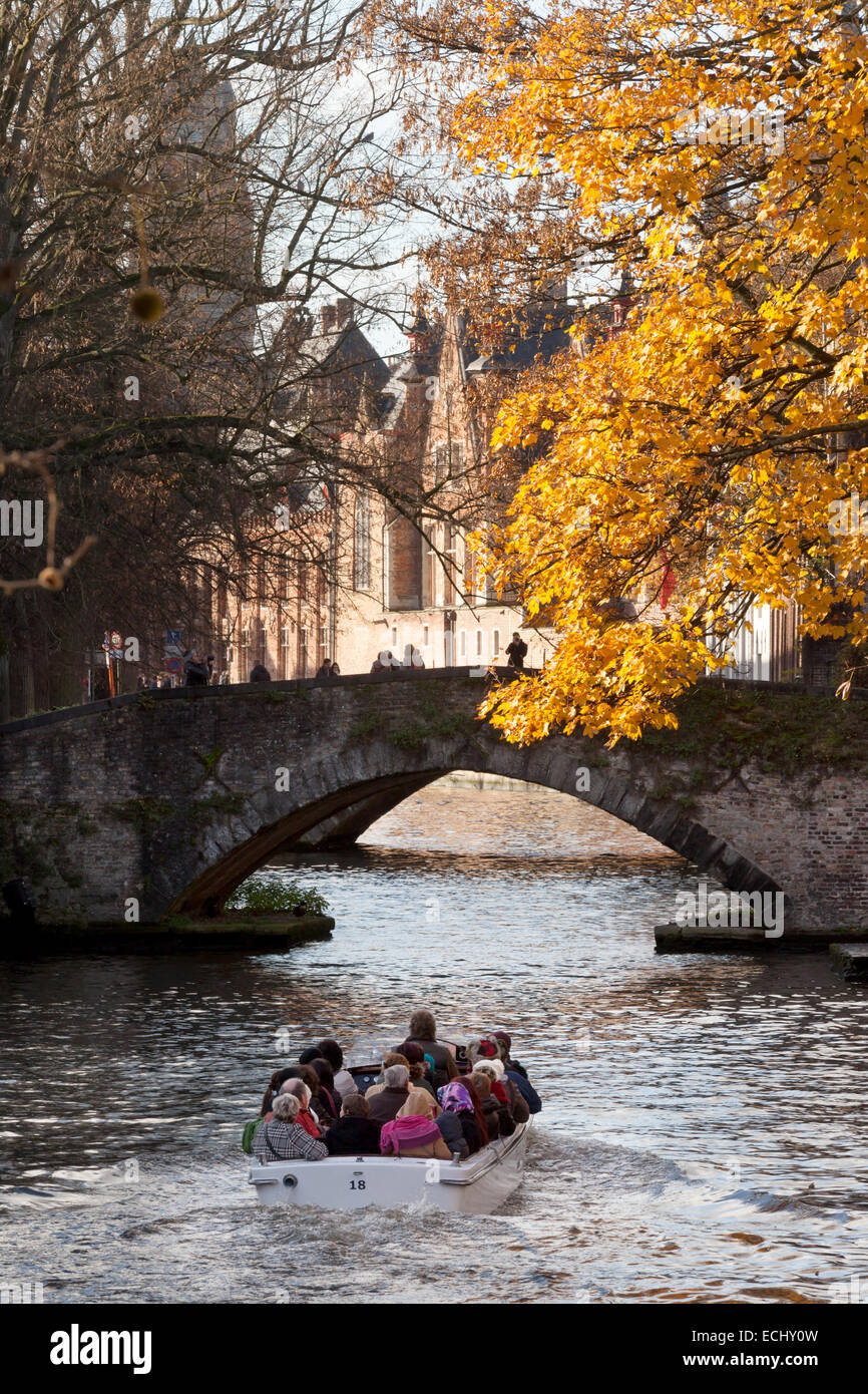 I turisti in una gita in barca sui canali in autunno; Bruges, Belgio, Europa Foto Stock