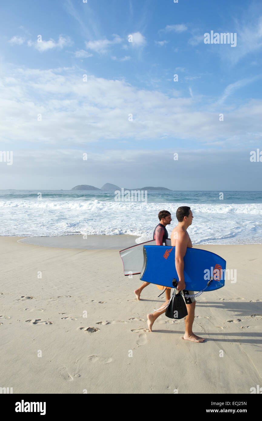 RIO DE JANEIRO, Brasile - 20 febbraio 2014: coppia di giovani surfisti brasiliano a piedi con pannelli del corpo lungo la spiaggia di Ipanema. Foto Stock