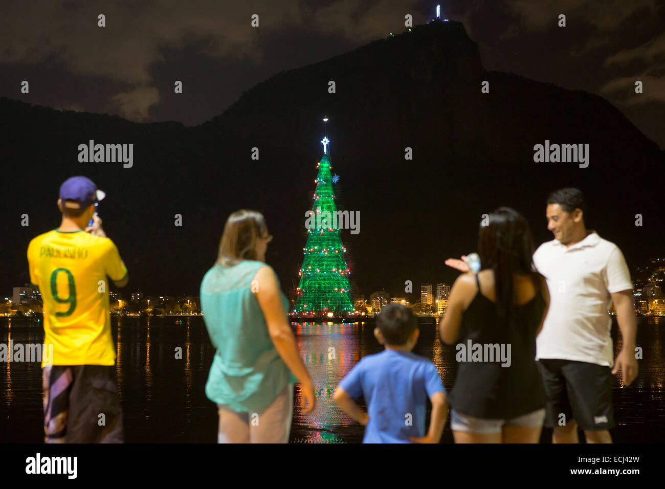 Rio De Janeiro, Brasile. 15 dic 2014. I visitatori guardano a un gigantesco albero di Natale sul Lago di Rodrigo de Freitas in Rio de Janeiro, Brasile, 15 dicembre 2014. L'albero gigante, che si trova a 85 metri di altezza e installato con circa 3,1 milioni di micro lampadine a LED è acceso ogni anno prima di Natale. Il tema della struttura di questo anno è "un Natale di luce". Credito: Xu Zijian/Xinhua/Alamy Live News Foto Stock