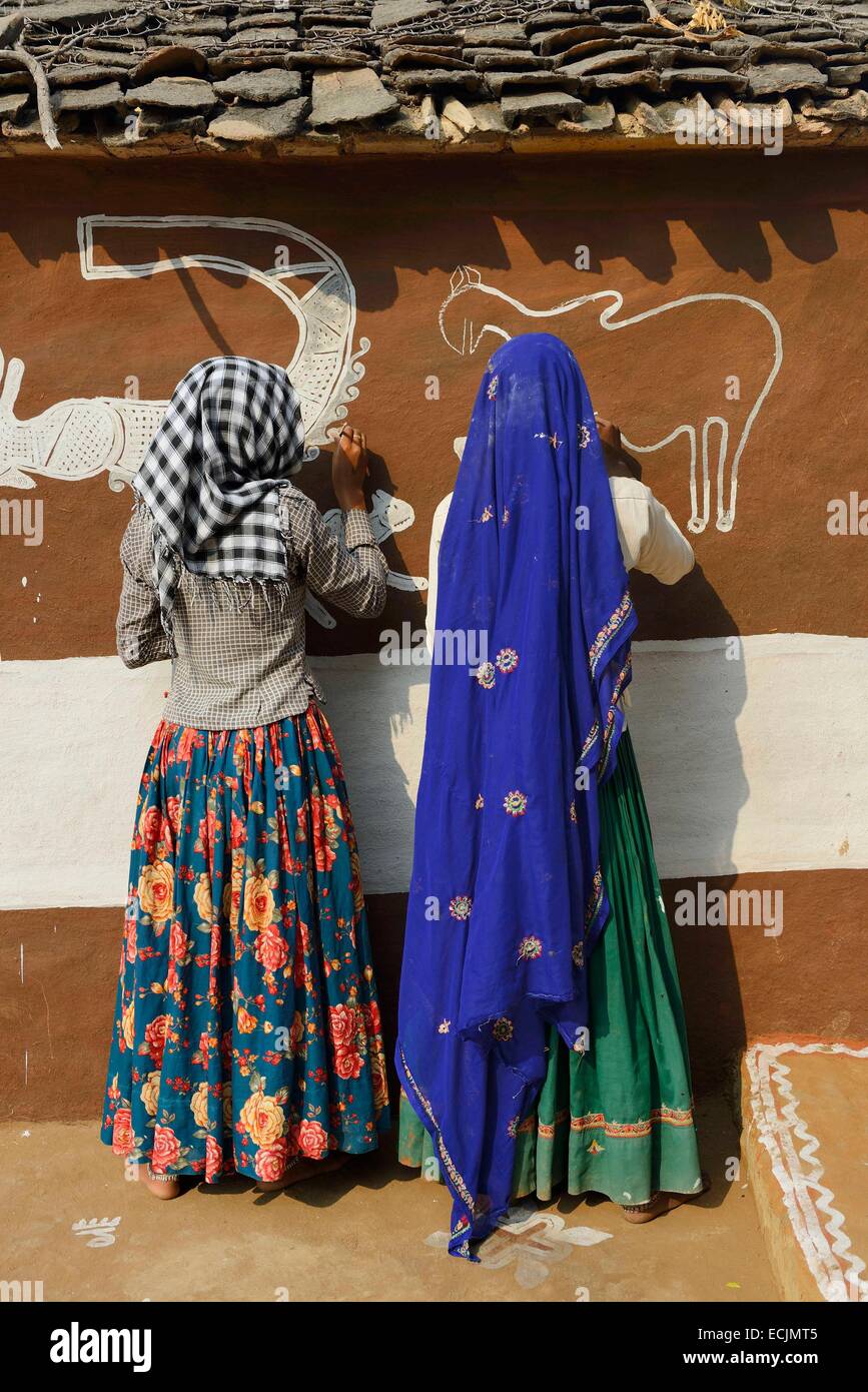India Rajasthan, Tonk regione, donne pittura pareti di argilla prima di Diwali Festival. Questi dipinti sono destinati ad accogliere la dea Lakshmi e di allontanare gli spiriti maligni Foto Stock