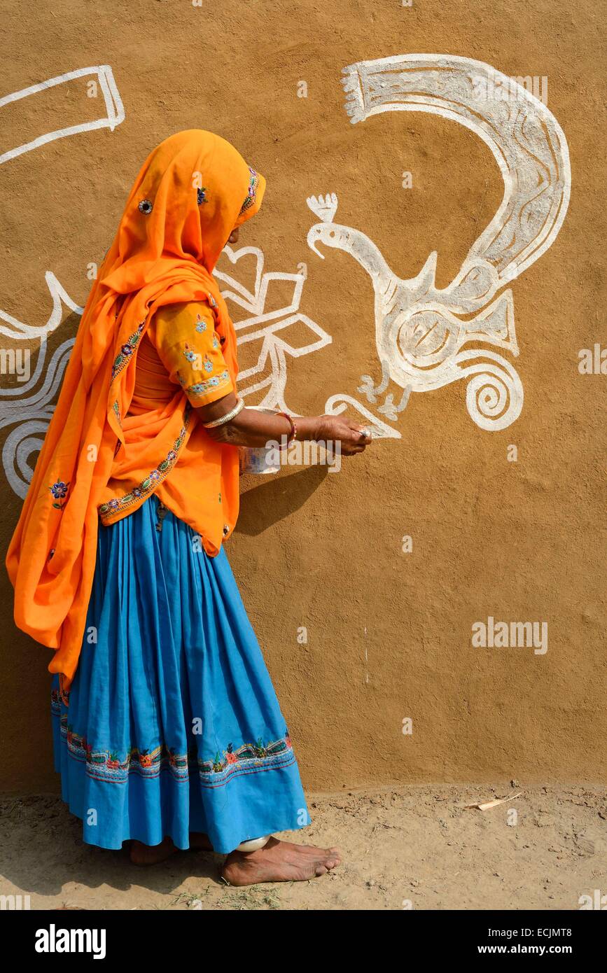 India Rajasthan, Tonk regione, Donna pittura pareti di argilla prima di Diwali Festival. Questi dipinti sono destinati ad accogliere la dea Lakshmi e di allontanare gli spiriti maligni Foto Stock