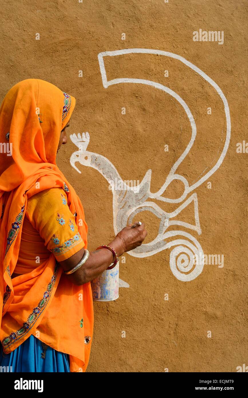 India Rajasthan, Tonk regione, Donna pittura pareti di argilla prima di Diwali Festival. Questi dipinti sono destinati ad accogliere la dea Lakshmi e di allontanare gli spiriti maligni Foto Stock