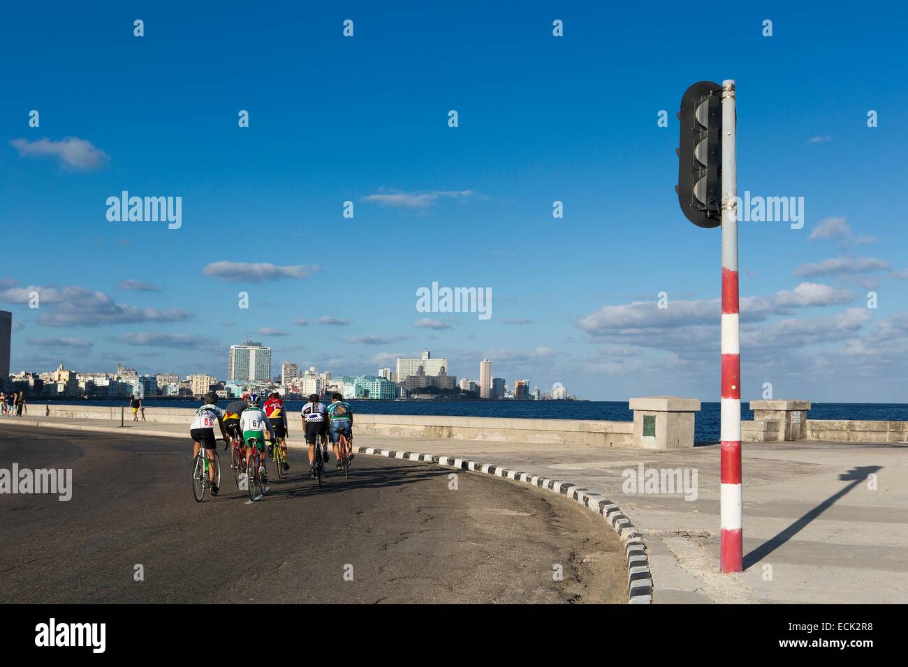Cuba, La Habana, ciclisti sul Malecon e Vedado district in background Foto Stock