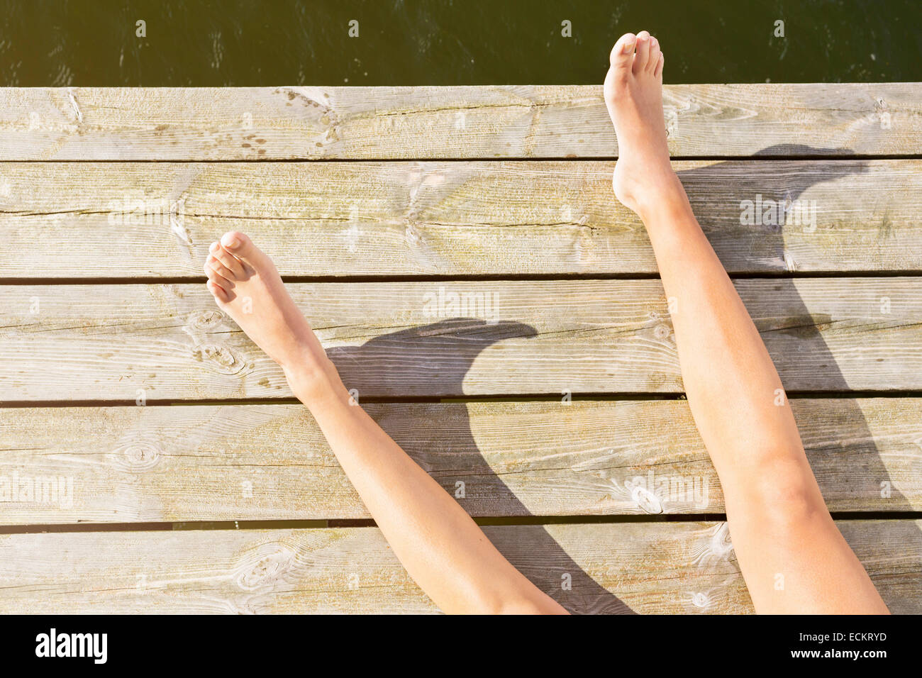 Sezione bassa della donna a prendere il sole sul lungomare Foto Stock