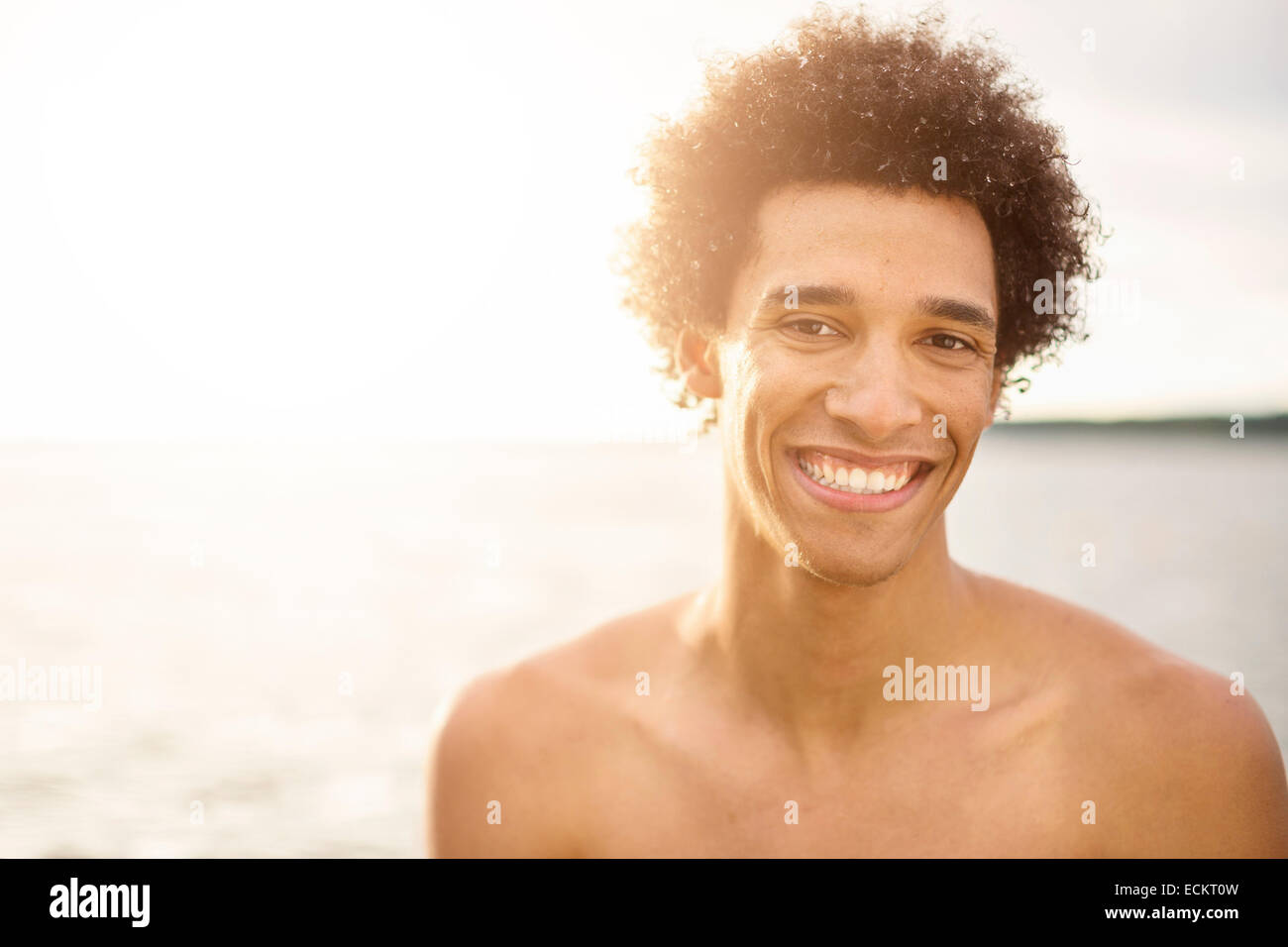 Ritratto di felice giovane uomo contro il lago Foto Stock