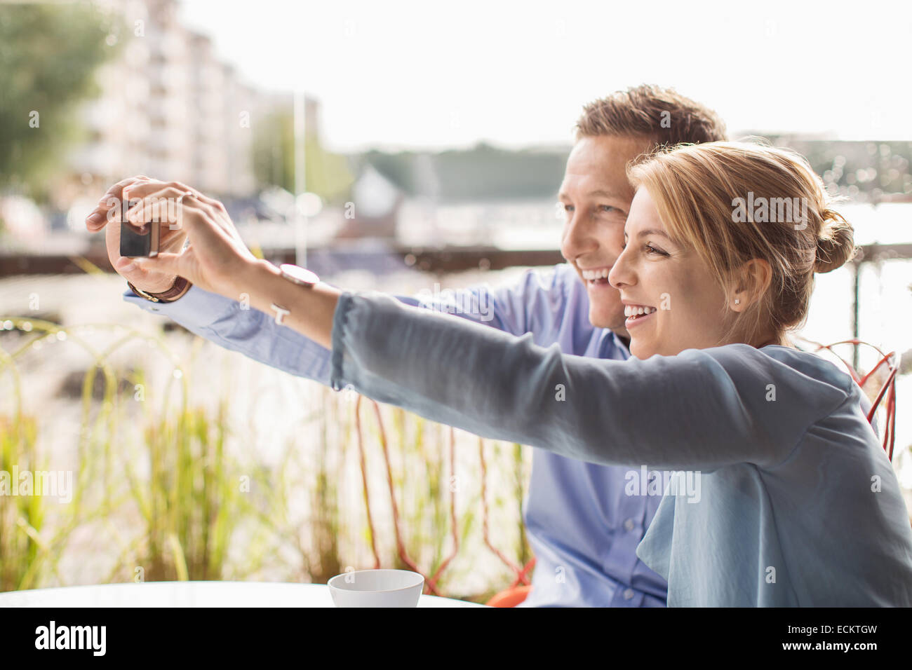 Sorridente la gente di affari tenendo selfie attraverso smart phone in cafe Foto Stock