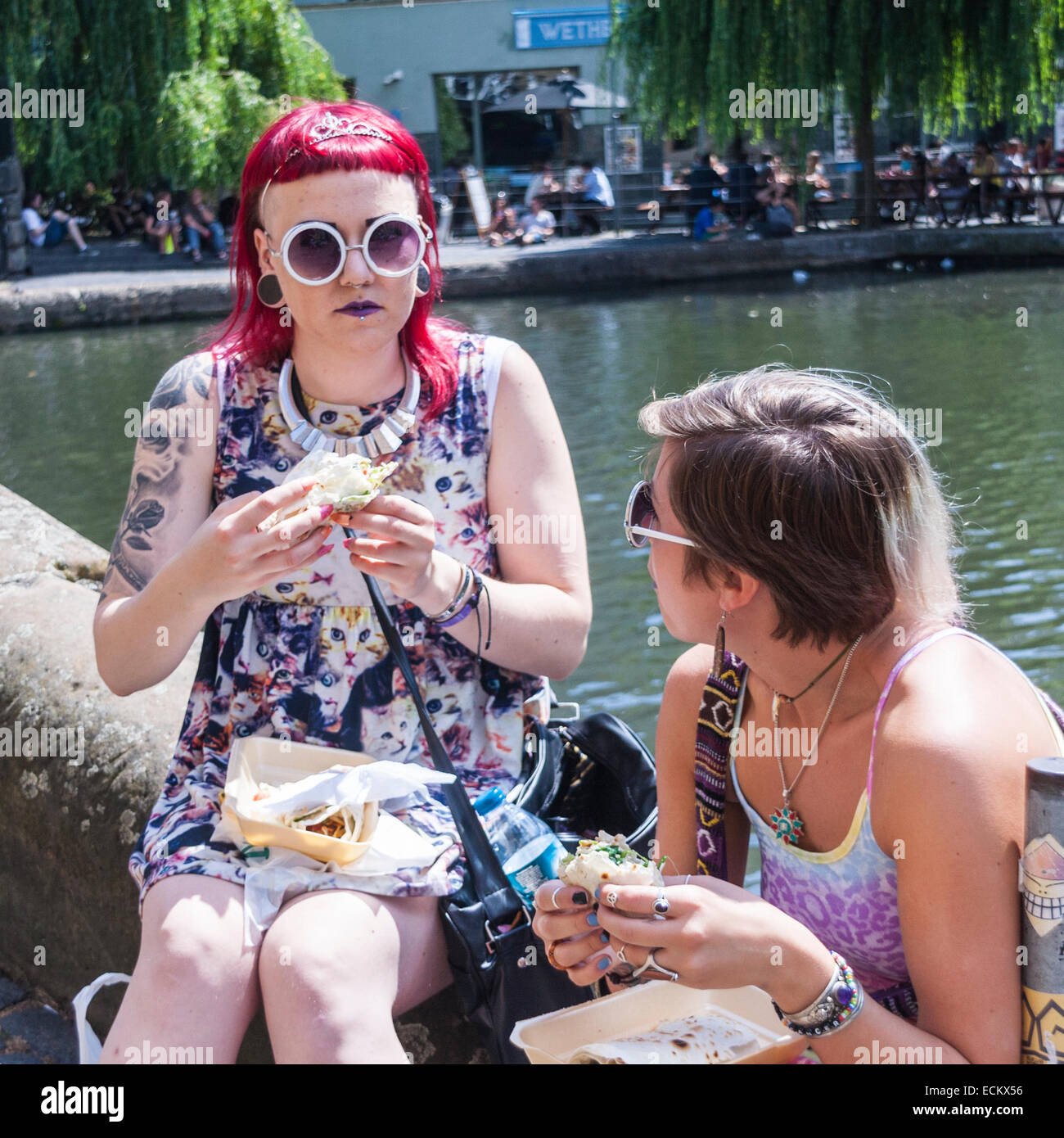Due donne sul lato di Camden Lock, mangiare Foto Stock