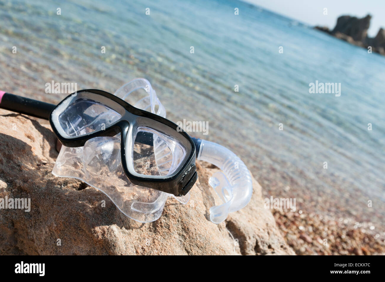 Attrezzatura per immersioni in appoggio su una spiaggia di roccia con il mare sullo sfondo Foto Stock