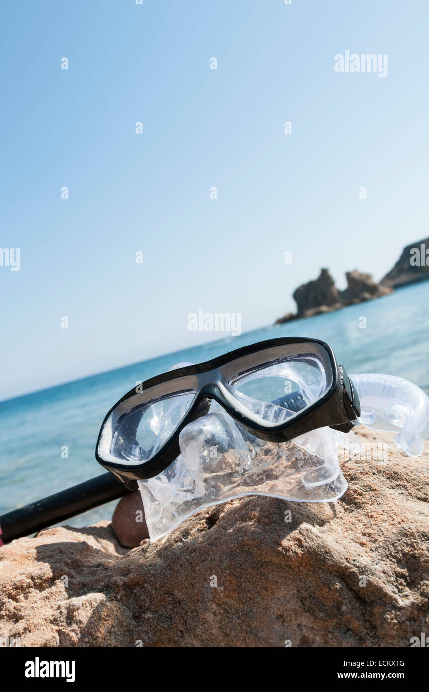 Attrezzatura per immersioni in appoggio su una spiaggia di roccia con il mare sullo sfondo Foto Stock