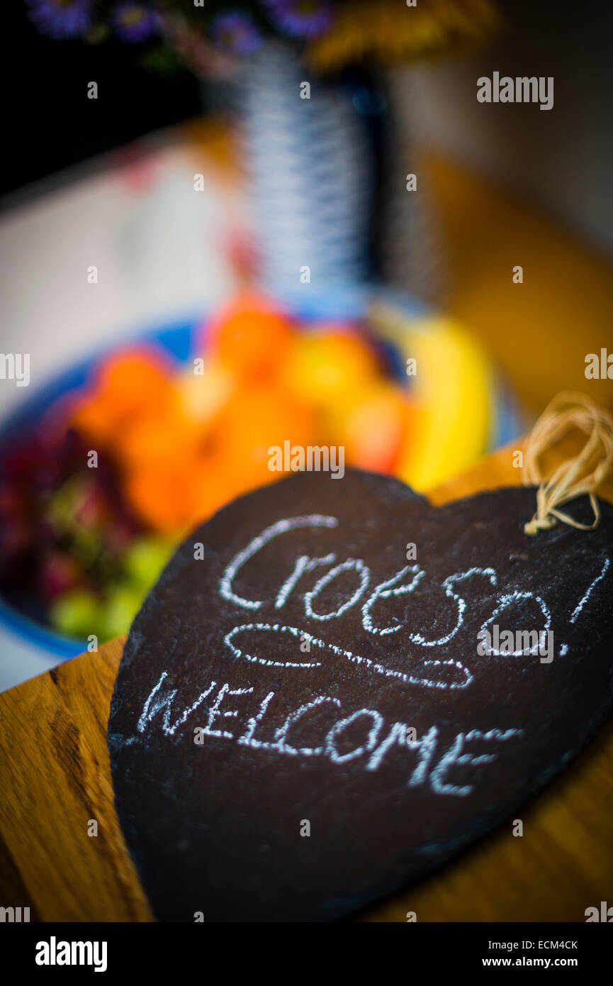 Croeso - la lingua gallese parola di benvenuto - scritto a mano in bianco gesso su un cuore pezzo sagomato di ardesia, Wales UK Foto Stock