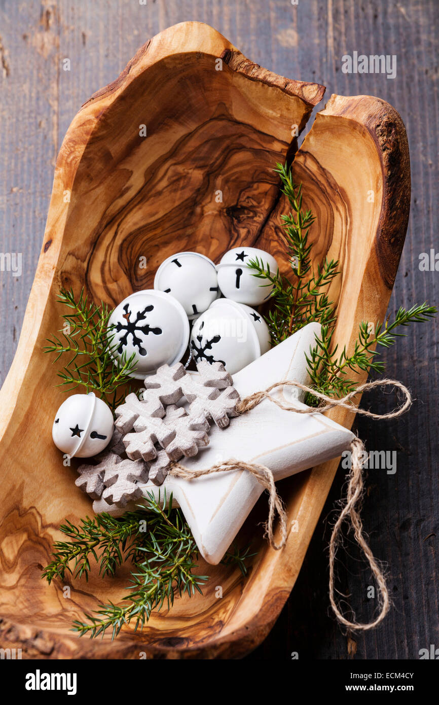 Le decorazioni di Natale le campane in legno d'olivo ciotola sul verde abete rami sullo sfondo Foto Stock
